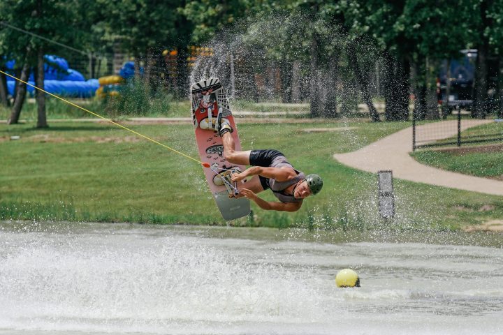 a group of people sitting around a fire hydrant in the grass