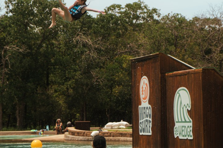 Little girl flying in the air from the wedge slides