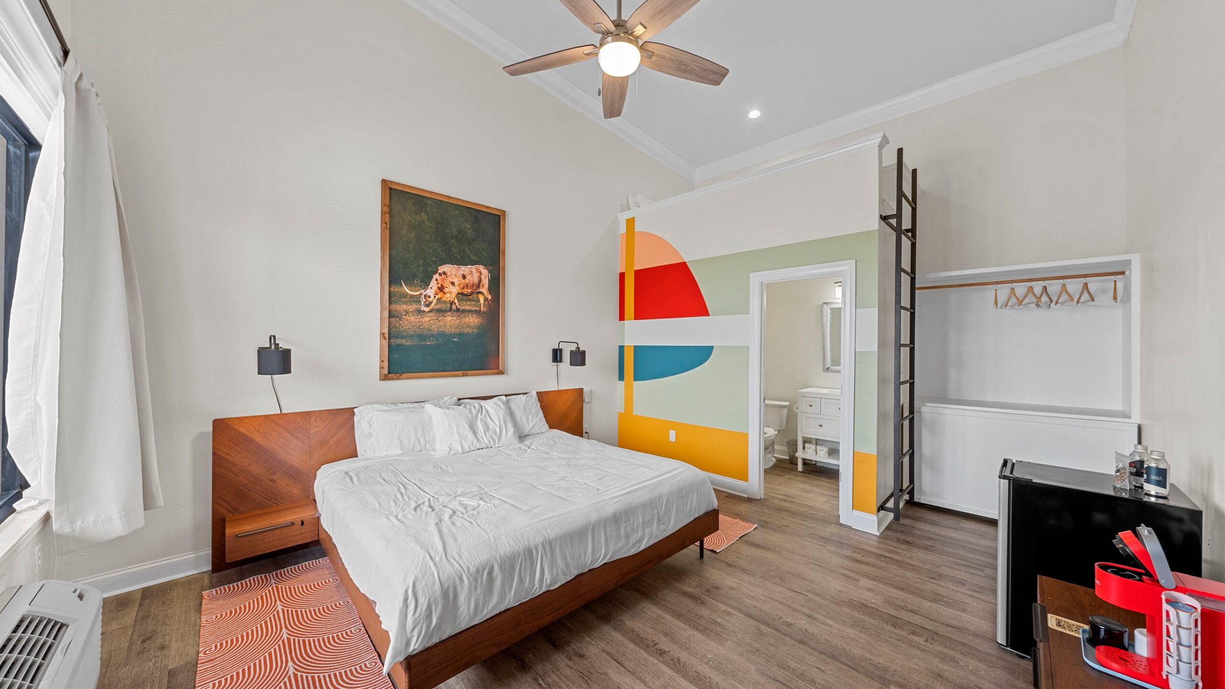 a bedroom with a bed and desk in a room