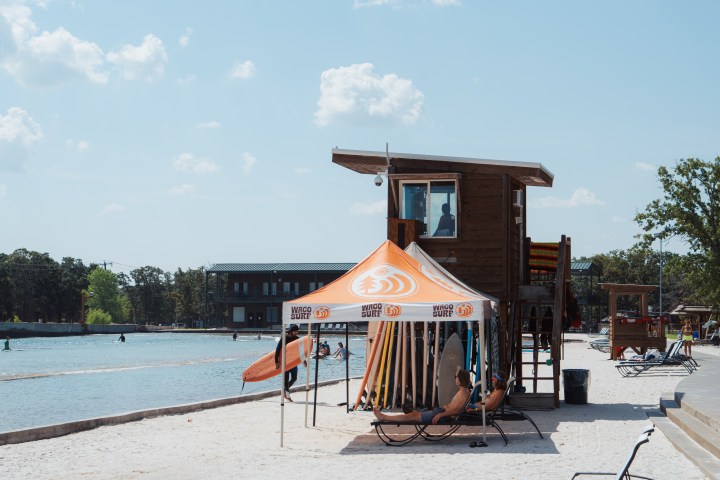 People relaxing next to the surf tower